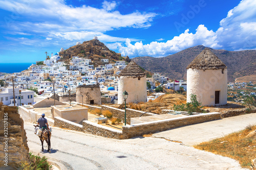 Traditional houses, wind mills, churches and donkey in Ios island, Cyclades, Greece.