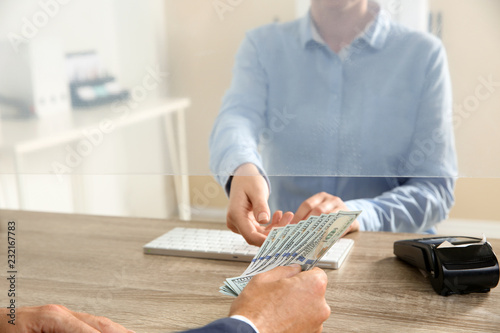 Man giving money to teller at cash department window, closeup
