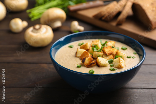 Bowl of fresh homemade mushroom soup on white background, top view