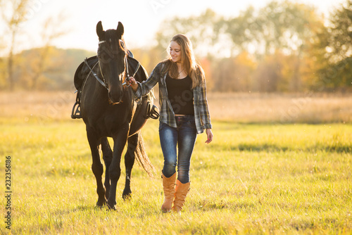 Dziewczyna jeździec stoi w pobliżu konia i przytula konia. Motyw konia