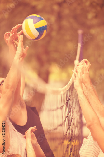 group of young friends playing Beach volleyball