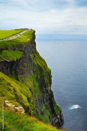 Photo of beautiful scenic sea and mountain landscape. Cliffs of Moher, west coast of Ireland, Atlantic ocean. View of ocean scenery