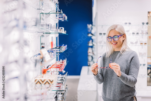 Woman looking at glasses at optic store.