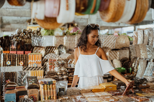 asian woman with tanned skin in the souvenir shop 