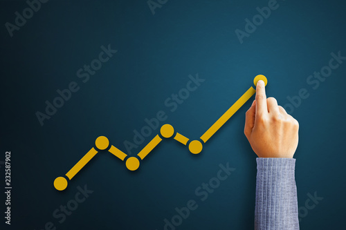 Businessman is touching arrows pointing up with graph as a symbol of growth and success or rising successful development and business development in the future