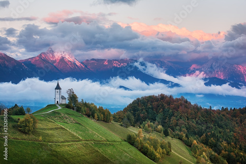 Beautiful sunrise landscape of church Jamnik in Slovenia with cloudy sky