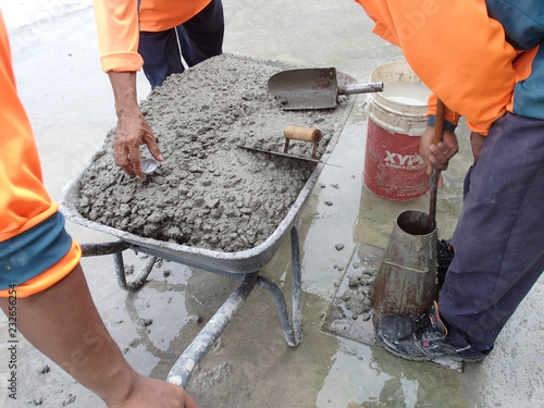 Construction workers doing slump test using specific equipment at the construction site. Witness by consultant. 