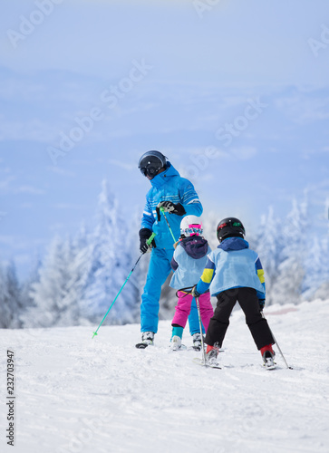 Children with teacher learning skiing