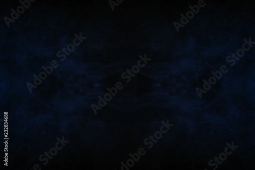 Abstract thick colored smoke on a black background with a monster face. The concept of light laser show at a musical concert and a print on a T-shirt