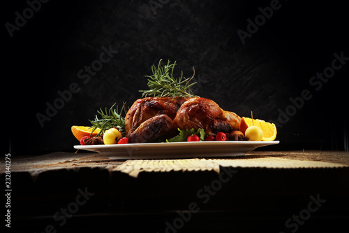 Baked turkey or chicken. The Christmas table is served with a turkey, decorated with fruits, salad and nuts. Fried chicken, table. Christmas dinner