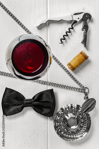 Overhead view of a glass of red wine with a sommelier tools.