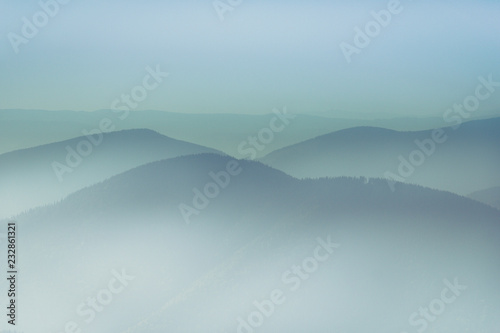 Misty mountain hills landscape. View of layers of mountains and haze in the valleys. The effect of color tinting.