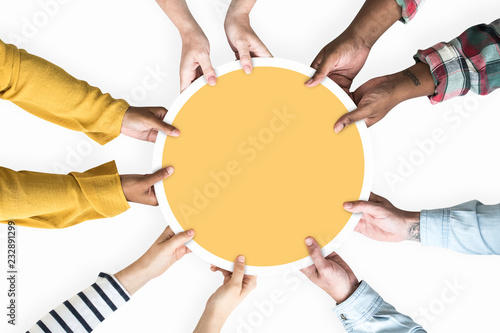 Diverse hands supporting a blank yellow round board