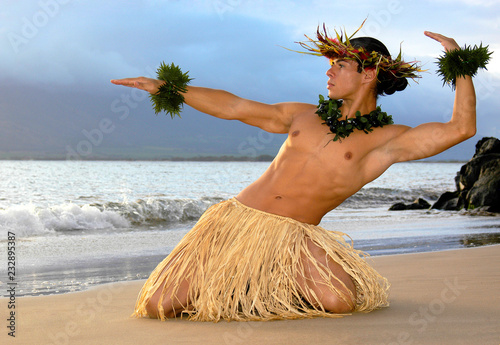 Male Hula Dancer performs on the beach a traditional masculine hula. 