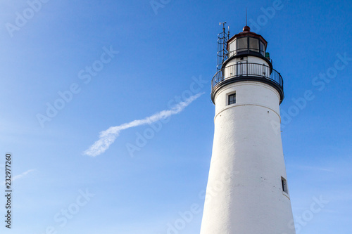 White Lighthouse Tower With Copy Space. The Fort Gratiot Lighthouse in Port Huron, Michigan shot under sunny blue sky with copy space. The lighthouse is the oldest active light on the Great Lakes. 