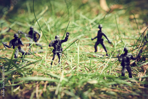 Soldiers in jungle fighting. Concept image of toy plastic soldiers in real grass. Selective focus.