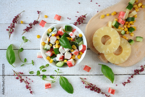 Light salad with crab sticks, pineapple, cucumber and corn