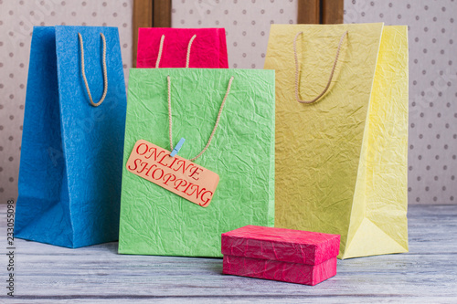 Set of multi-colored shopping bags. Group of colorful gift bags, gift box and card with inscription online shopping. Commerce, marketing and lifestyle.