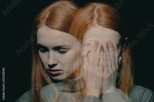 Porter of beautiful redhead girl with psychotic disorders covering her face, hiding from her hallucinations