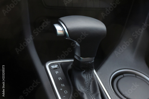 Car interior. Black leather automatic gearbox with chrome button and round ashtray 