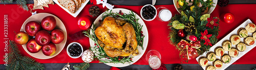Baked turkey. Christmas dinner. The Christmas table is served with a turkey, decorated with bright tinsel and candles. Fried chicken, table. Family dinner. Top view