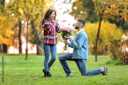 Young man proposing to his beloved in autumn park