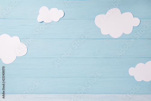 Cute children or baby card, white clouds on the blue wooden background