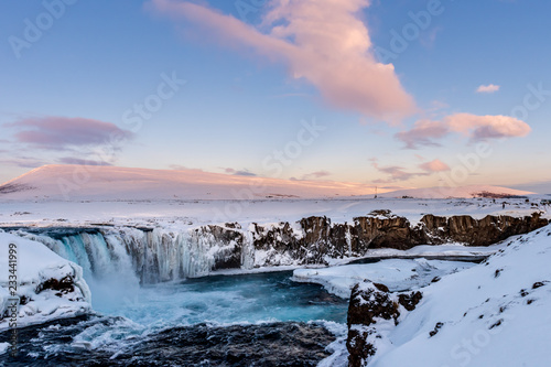 Frozen Godafoss waterfall on cold winters day at dawn, Northern Iceland