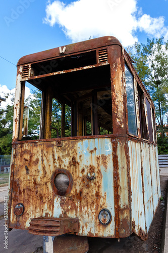 Old rusty destroyed tram outdoors at sunny day.