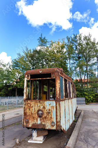 Old rusty destroyed tram outdoors at sunny day.