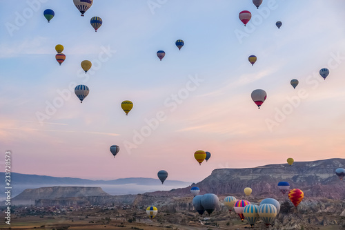 Hot air balloon flying over spectacular Cappadocia, Tourists enjoy the overwhelming views over Cappadocia, Turkey.