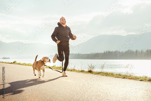 Poranny jogging ze zwierzakiem: mężczyzna biegnie razem ze swoim psem beagle