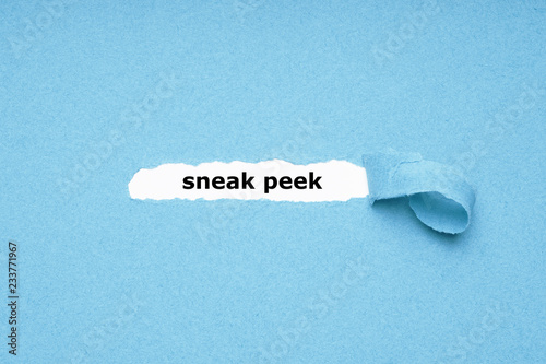 sneak peek text revealed by peeling off torn blue paper background - abstract preview concept