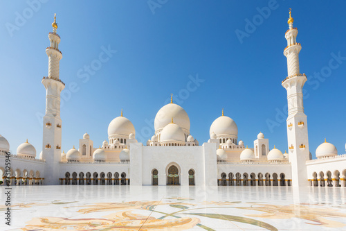 Sheikh Zayed Mosque - Abu Dhabi, United Arab Emirates. Beautiful white Grand Mosque courtyard with unique marble floor and minarets in each corner.