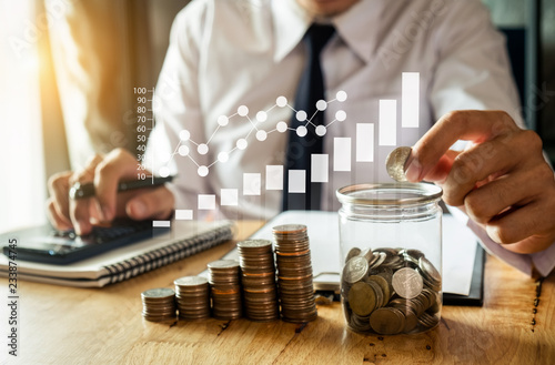 businessman holding coins putting in glass with using smartphone and calculator to calculate concept saving money for finance accounting