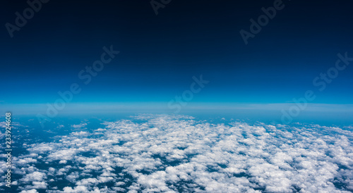Above the clouds. High flight and view of near edge of space at 35,000 feet. Looking out the air plane window. 