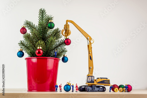 Miniature workers decorating christmas tree