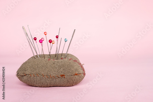 sewing pins on pink background.