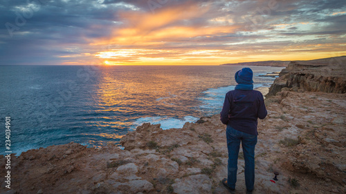 Women looking out towards a beautiful sunset over the ocean atop the Zuytdorp Cliffs on Dirk Hartog island, Western Australia