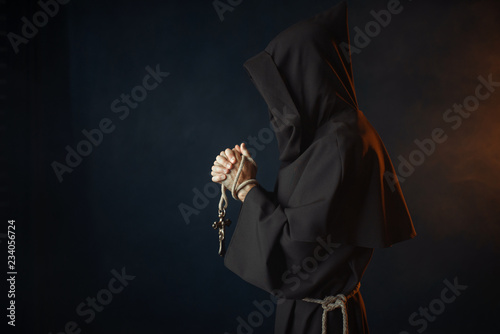 Medieval monk praying with closed eyes