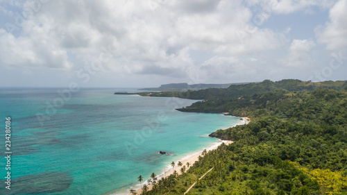View of the ocean coast beach and mountains. Secluded white sand beach and mountains. Summertime Sea tranquility. Aerial view