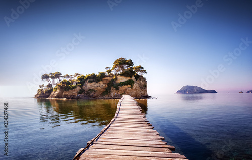 Picturesque view on lonely island Cameo in Greece, part of island Zakinthos or Zante, Port Sostis. Dramatic scenery of solitude island in ocean with wooden path. Iconic landmark on Zakinthos island.