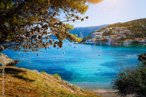 Beautiful blue bay surrounded by pine trees in Assos village located on Kefalonia. Summer tourism vacation trip around Greece