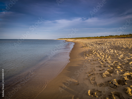 Long, empty and clean sand Stogi beach in the sunset near Gdansk, Poland with dramatic blue sky