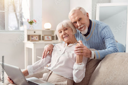 Beautiful couple. Elderly beautiful couple spending weekend while watching photos at the laptop