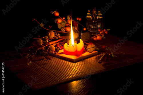 Statue of Tutankhamun and brier lit by a candle