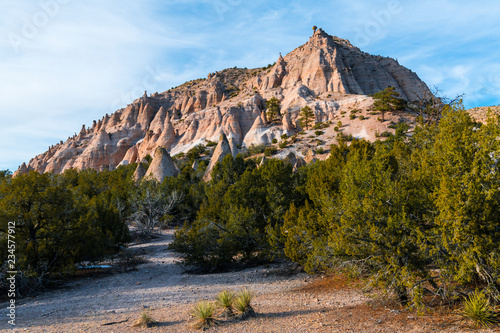 Colorful red rock peak with numerous hoodoo rock formations in evening light at Kasha-Katuwe Tent Rocks National Monument near Santa Fe, New Mexico