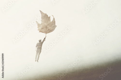 man flying with a big leaf in the sky