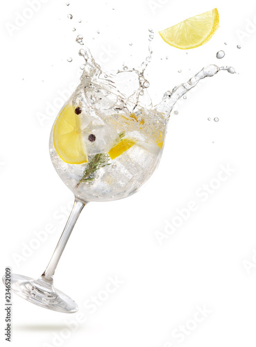 lemon slice falling into a splashing gin tonic 