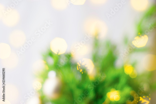 Beautiful Christmas New Year Background. Decorated fir tree branches golden garland bokeh lights. Festive atmosphere. Defocused. Poster banner flyer template